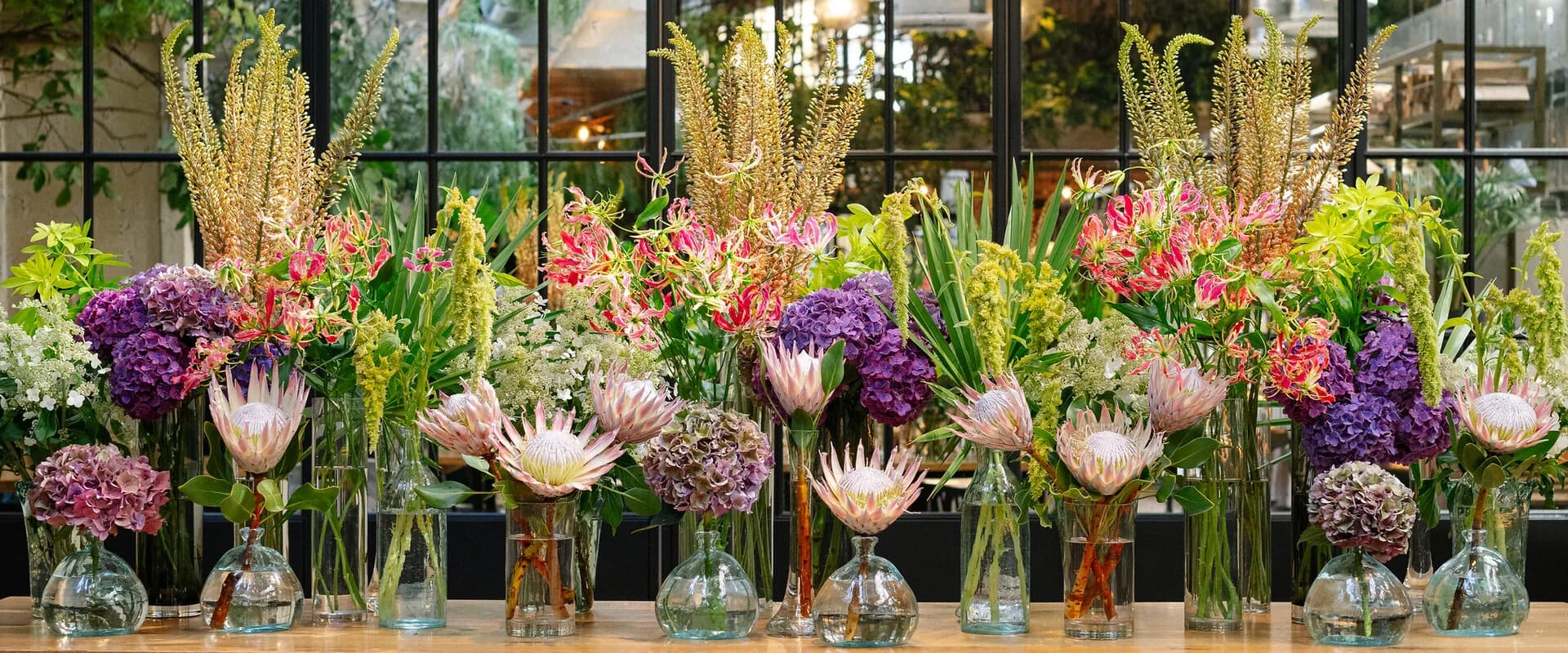 A considered floral installation in a candlelit private dining room