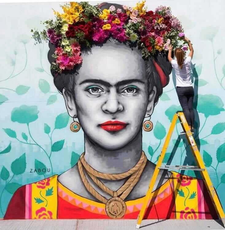 Frida Kahlo mural by street artist Zabou, surrounded by floral installations