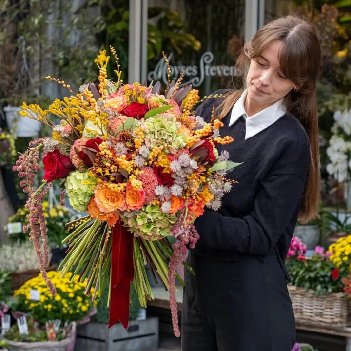 A Moyses Stevens florist arranging seasonal flowers in the studio
